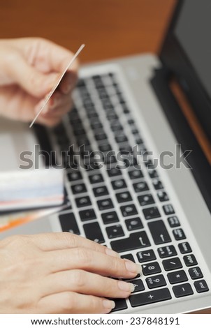 woman entering credit card number. On-line money transaction concept.