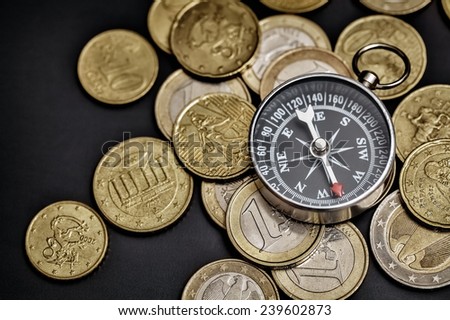 Compass on euro coins. Compass showing financial success route.