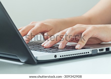 Macro photo of female hands typing on laptop. businesswoman working at office computer.