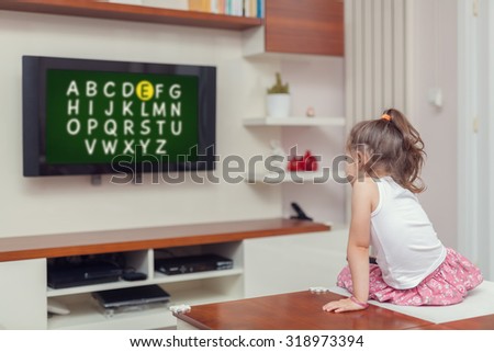 cute little girl learning alphabet on tv.