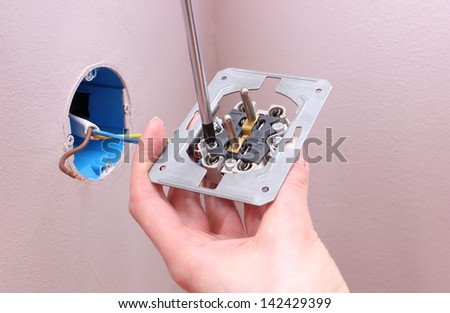 Hand of an electrician installing a power socket