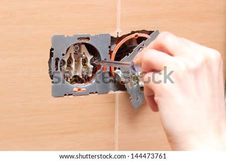 Hand of an electrician installing a power socket