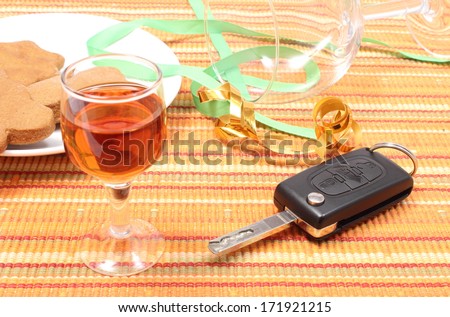 Closeup of car key with glass of wine lying on table after party, car key and alcohol, don\'t drink and drive concept