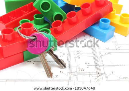 Closeup of home keys and heap of colorful building blocks lying on construction drawing of house, building blocks for children, housing plan with building blocks