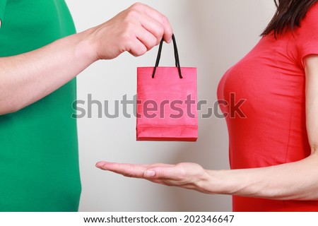 Hand of man giving birthday gift to woman