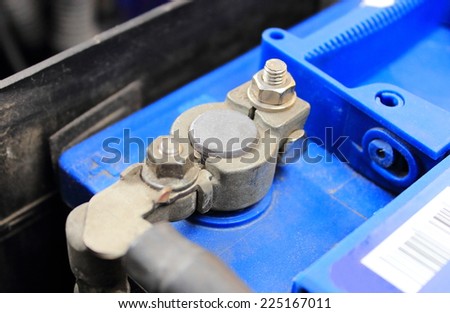 Cables connected to car battery under hood of car