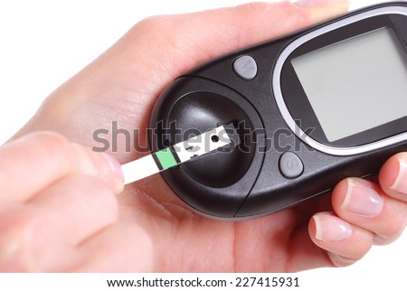 Closeup of strip for glucose testing and glucose meter, measuring sugar level. Isolated on white background