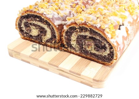 Closeup of poppy seed cake, rolled up traditional polish poppy cake on wooden cutting board
