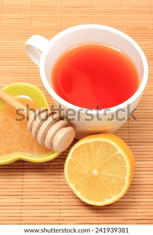 Cup of healthy tea with honey and lemon on wooden background, concept for healthy nutrition
