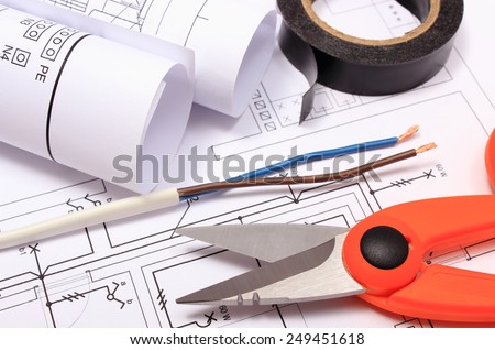 Cable cutter, electric wire and black insulating tape, rolls of electrical diagrams lying on construction drawing of house, accessories for engineer jobs