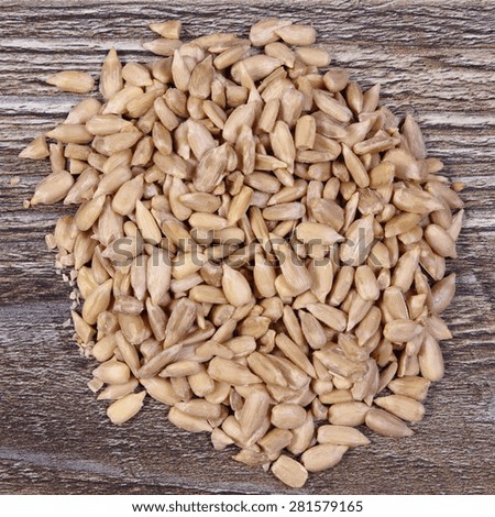 Heap of sunflower seeds on wooden background, concept for eating and nutrition