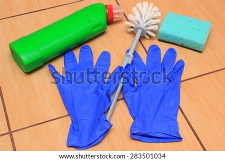 Accessories for cleaning bathroom on ceramics flooring, brush, glove, sponge, concept for house cleaning and household duties
