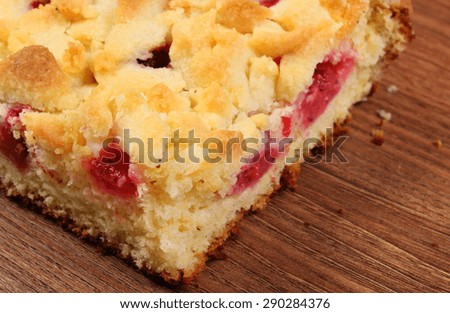 Fresh baked yeast cake with crumble and strawberries on wooden surface, concept for dessert