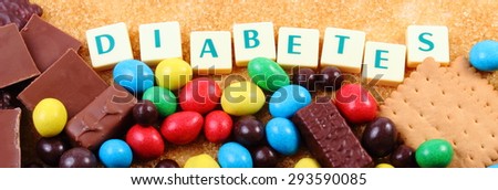Heap of sweet candies and cookies with brown cane sugar and word diabetes, unhealthy food, concept of diabetes and reduction of eating sweets