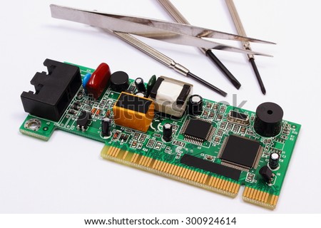 Printed circuit board with electrical components and precision tools lying on white background, precision tools for engineer jobs, technology