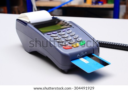 Payment terminal with credit card on desk in store, credit card reader, payment terminal, finance concept