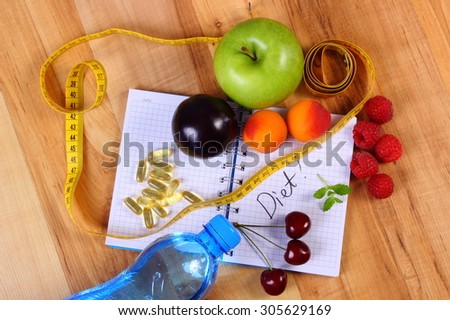 Fruits with mineral water, tape measure and tablets supplements on notebook for writing notes, choice between healthy eating and slimming pills