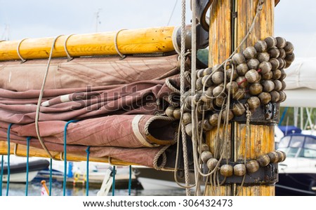 Yachting, parts of old wooden sailboat in port of sailing, coiled rope, sail, details of yacht