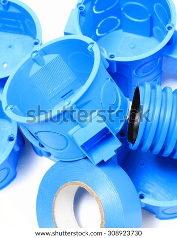 Heap of blue electrical boxes and components for use in electrical installations, accessories for engineering jobs