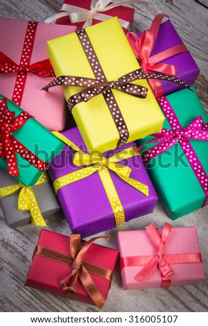 Heap of wrapped colorful gifts for Christmas, birthday or other celebration on old wooden white plank