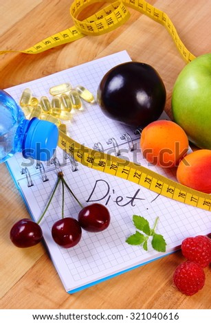 Fruits with mineral water, tape measure and tablets supplements on notebook for writing notes, choice between healthy eating and slimming pills