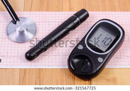 Glucose meter with lancet device and medical stethoscope lying on electrocardiogram graph, ecg heart rhythm, medicine and health care concept