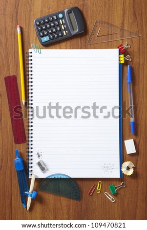 Back to School pupils note pad and stationary on wooden school desk from above