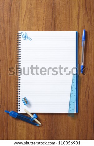Back to School pupils note pad and stationary on wooden school desk from above