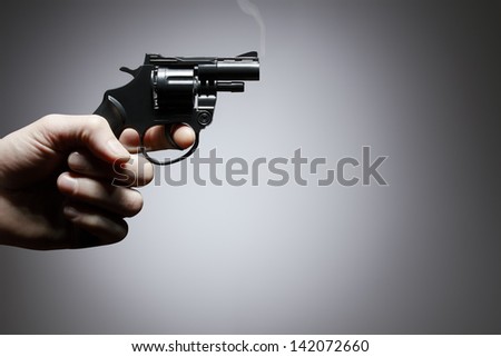 Gun crime concept of hand pistol on grey background