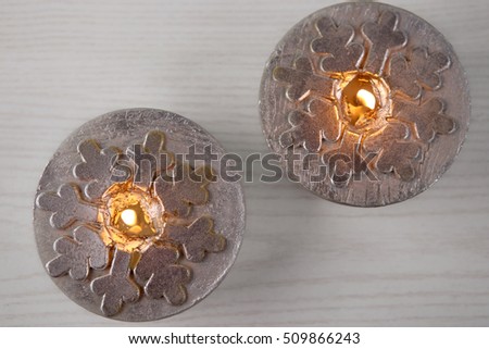 Silver  candles  with snowflakes. Winter, Christmas decoration on wooden white background. Top view.