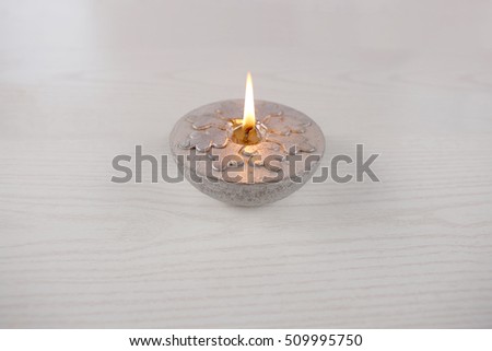 Silver  candle  with snowflake. Winter, Christmas decoration on wooden white background.
