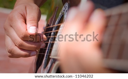Playing acoustic guitar - great shot detail of a guitarist hands