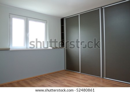 New empty bedroom with window and wardrobe