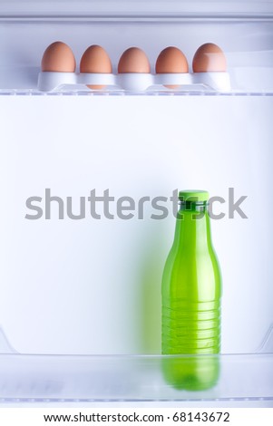 Inside the fridge are five eggs and a bottle of milk