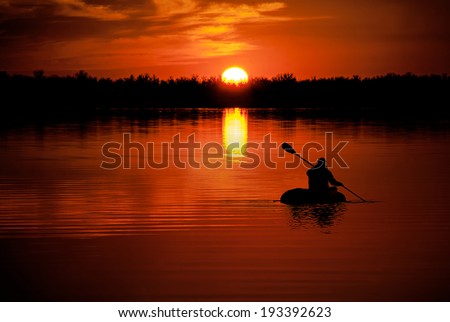 man in kayaking on Lake  at sunset