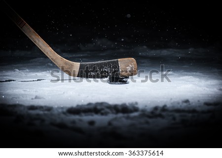 Hockey Stick and Puck on the Ice Rink