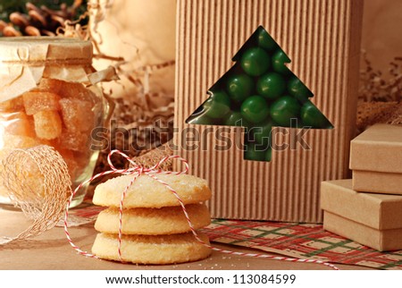 Christmas still life of food gifts with eco friendly wrapping paper and gift packaging (pine cones in background)  Close-up with shallow dof.  Selective focus on cookies tied with baker\'s twine.