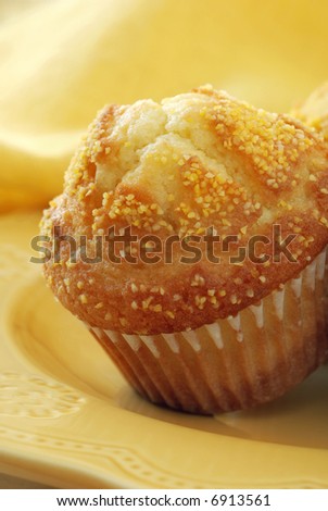 Macro of corn muffin on yellow plate with matching napkin as background. Shallow dof