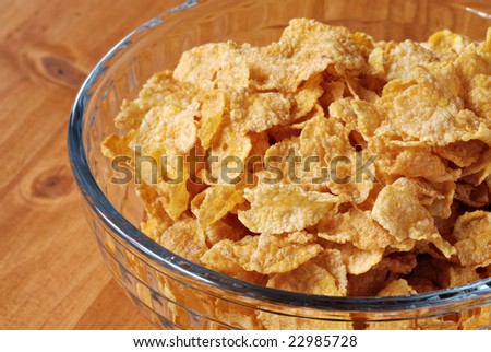 Corn flake cereal in glass bowl on wood background.  Macro with shallow dof.