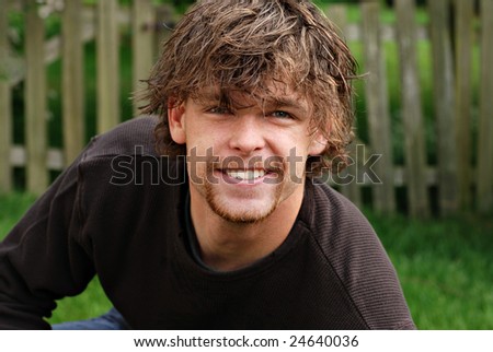 Handsome twenty-one year old male college student with tousled hairstyle.  Casual outdoor portrait with shallow dof.