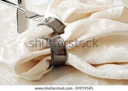 Elegant cream colored damask table napkins with decorative rings.  Macro with shallow dof.