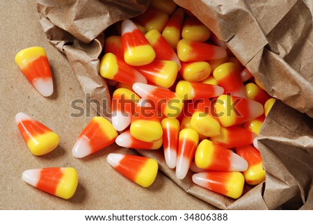 Colorful candy corn spilling from brown paper bag.  Macro with shallow dof.
