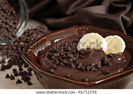 Delicious creamy chocolate pudding topped with chocolate chips and banana slices. Still life with extremely shallow dof.  Selective focus on banana.