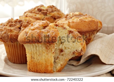 Freshly baked cinnamon muffins with sunlit window in background.  Closeup with shallow dof.