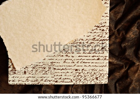 Background image with parchment paper over a page with faux handwriting (non legible) and brown suede fabric.