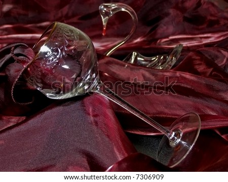 wineglass from crystal against red tissue and swan figure
