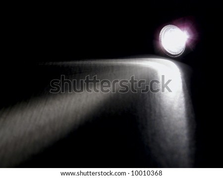 Lighting flashlight at dark night with light like arrow