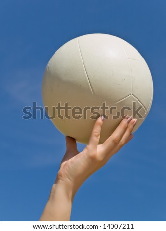 white ball in the woman hand against the blue sky