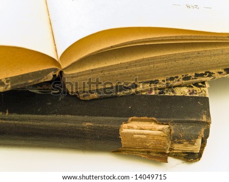 Old open book with closed book at the white table