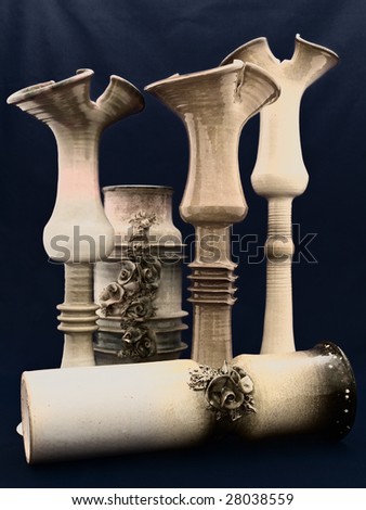 different ceramic vases over dark blue background